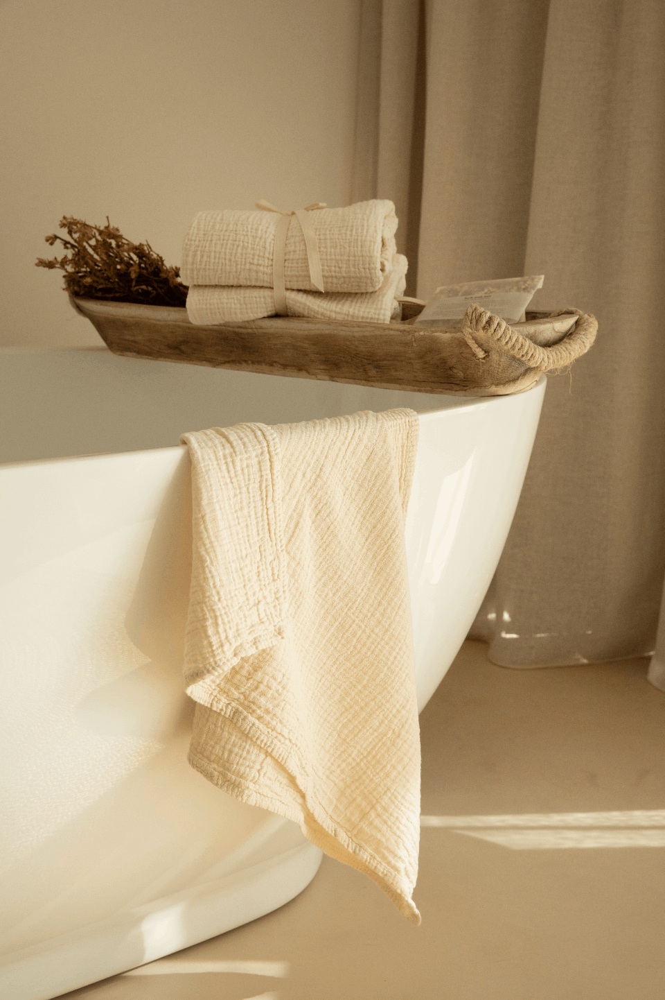 Oatmeal crinkle-cotton towels by atelier an.nur photographed in a soft, warm bathroom scene with a towel draped over a bathtub